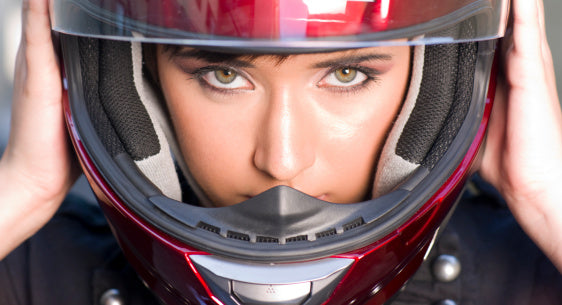 Young woman looking straight ahead with a red helmet on